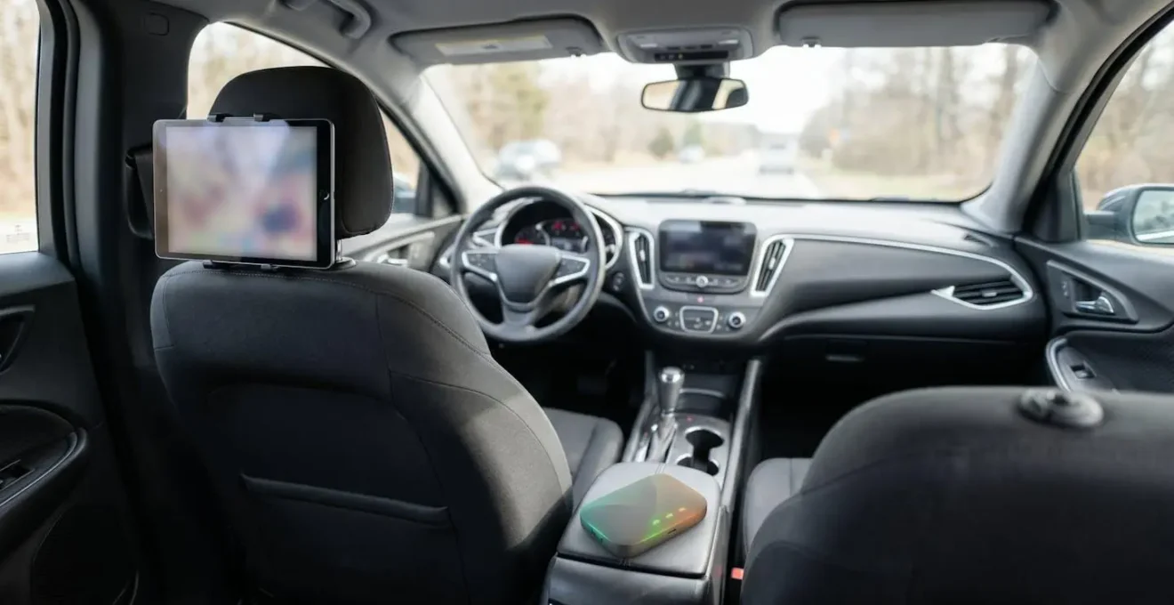 Moderner Autoinnenraum mit einem mobilen Router im Getränkehalter und vernetzten Tablets, die eine stabile Konnektivität für Familienreisen symbolisieren.