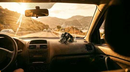 Beschaedigtes minderwertiges Autozubehoer im heissen Fahrzeuginnenraum waehrend Europa-Roadtrip